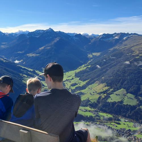 4 Schüler sitzen auf einer Bank und schauen ins Tal