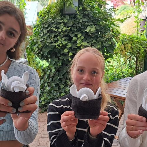 Drei Schülerinnen präsentieren ihre Handtuch-Pinguine