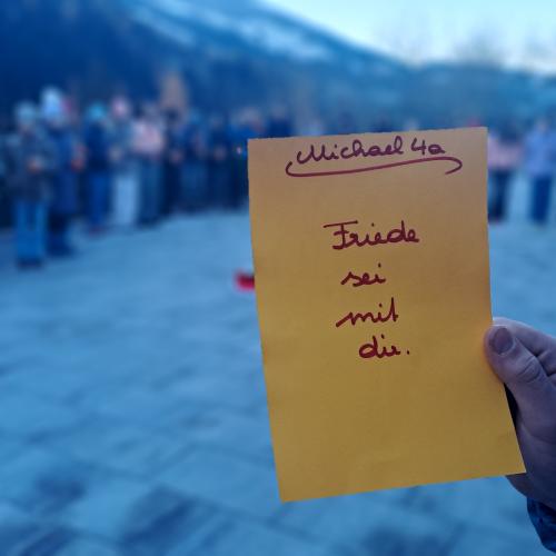 Ein Schüler hält einen gelben Zettel in der Hand