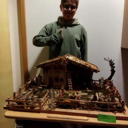 Ein Schüler präsentiert seine Weihnachtskrippe