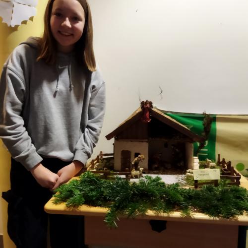 Eine Schülerin präsentiert ihre Weihnachtskrippe
