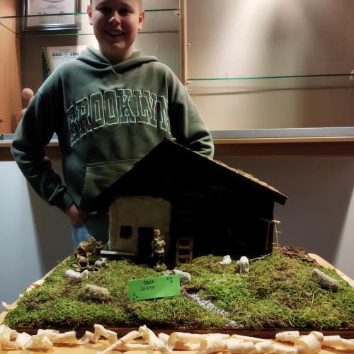 Ein Schüler präsentiert seine Weihnachtskrippe