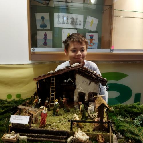 Ein Schüler präsentiert seine Weihnachtskrippe