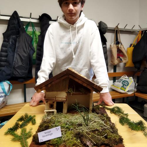 Ein Schüler präsentiert seine Weihnachtskrippe