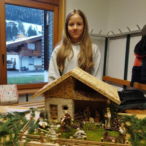 Eine Schülerin präsentiert ihre Weihnachtskrippe