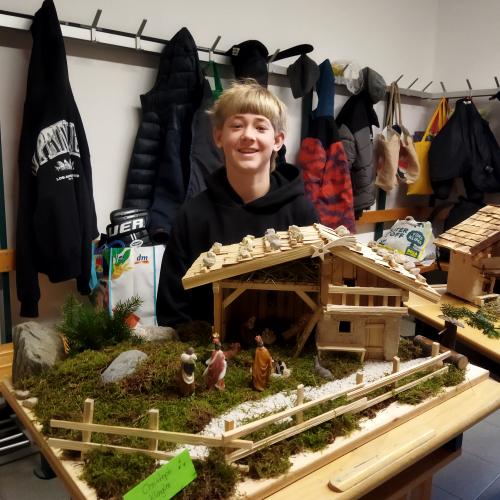 Ein Schüler präsentiert seine Weihnachtskrippe