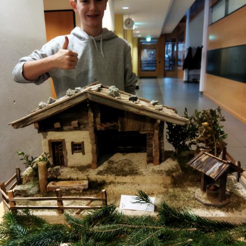 Ein Schüler präsentiert seine Weihnachtskrippe