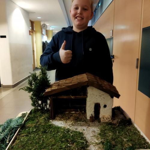 Ein Schüler präsentiert seine Weihnachtskrippe