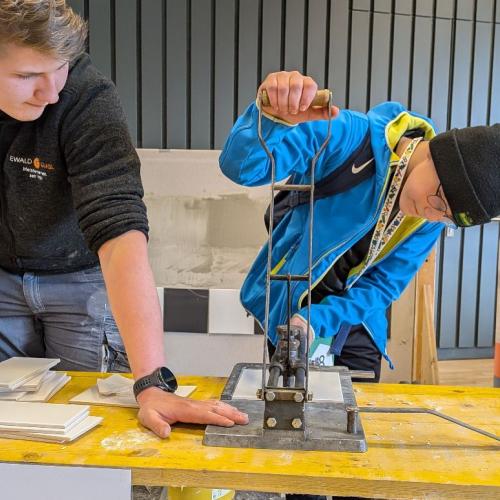 Ein Schüler schneidet eine Fliese