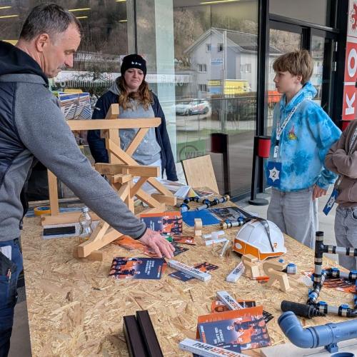 Schülern wird die Tätigkeit eines Zimmermanns erklärt
