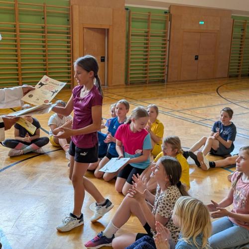 Schülerinnen und Schüler in der Turnhalle sitzend
