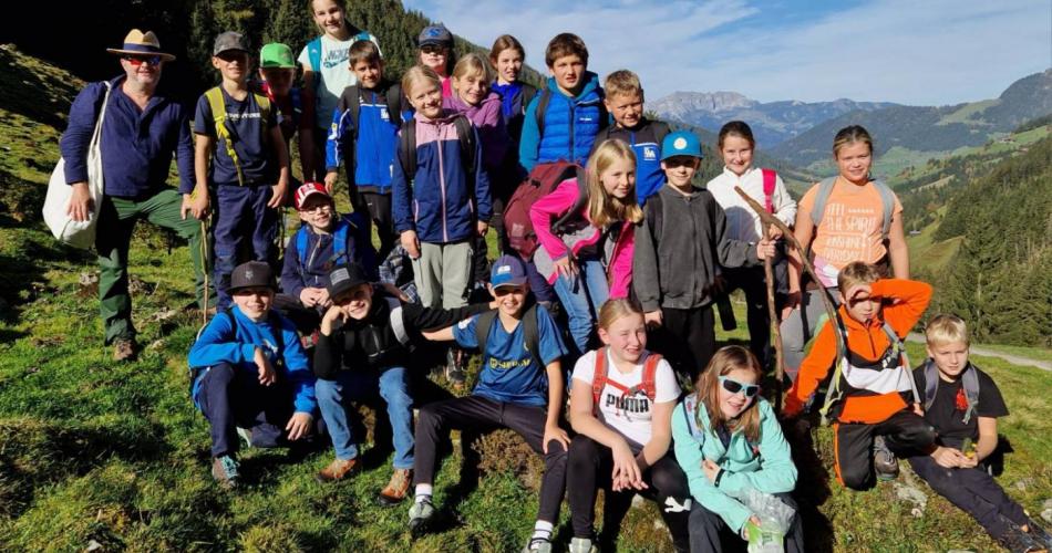 Schüler:innengruppe mit Lehrperson auf einen Felsen