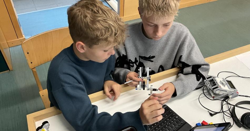Zwei Personen bauen einen Roboter