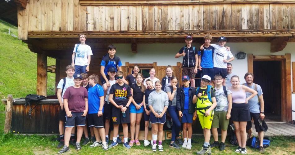 Kinder vor einer Almhütte