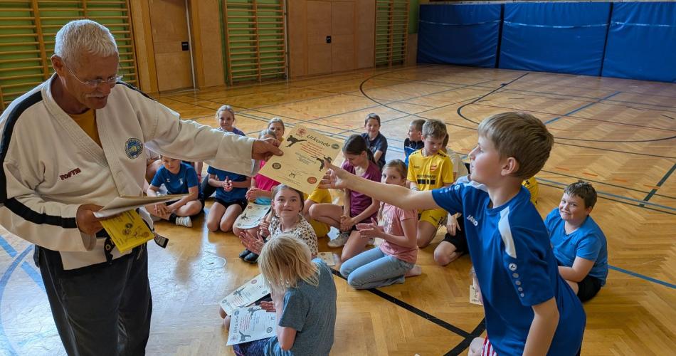 Ein Schüler nimmt die Urkunde entgegen
